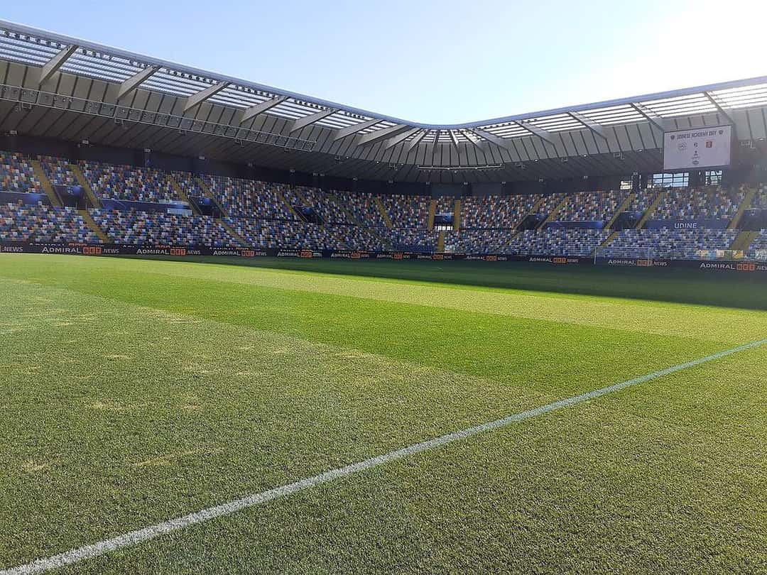 La cancha del estadio del Udinese, en Udine, vista desde el borde del césped, con las tribunas de butacas de colores bajo el techo; foto de archivo de diciembre de 2024 (foto: Holapaco77, Wikimedia Commons, licencia CC BY 4.0)