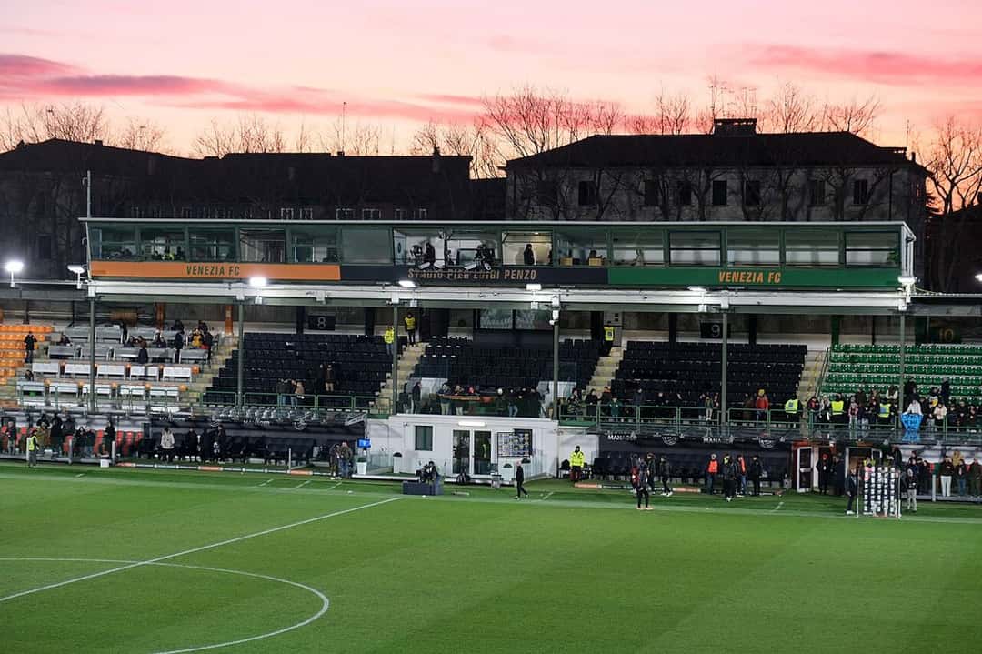 Vista de la tribuna principal del estadio Pier Luigi Penzo, con los colores naranja, negro y verde del Venezia, al atardecer antes de un partido de la Serie A; foto de archivo de enero de 2025 (foto: kallerna, Wikimedia Commons, licencia CC BY-SA 4.0)