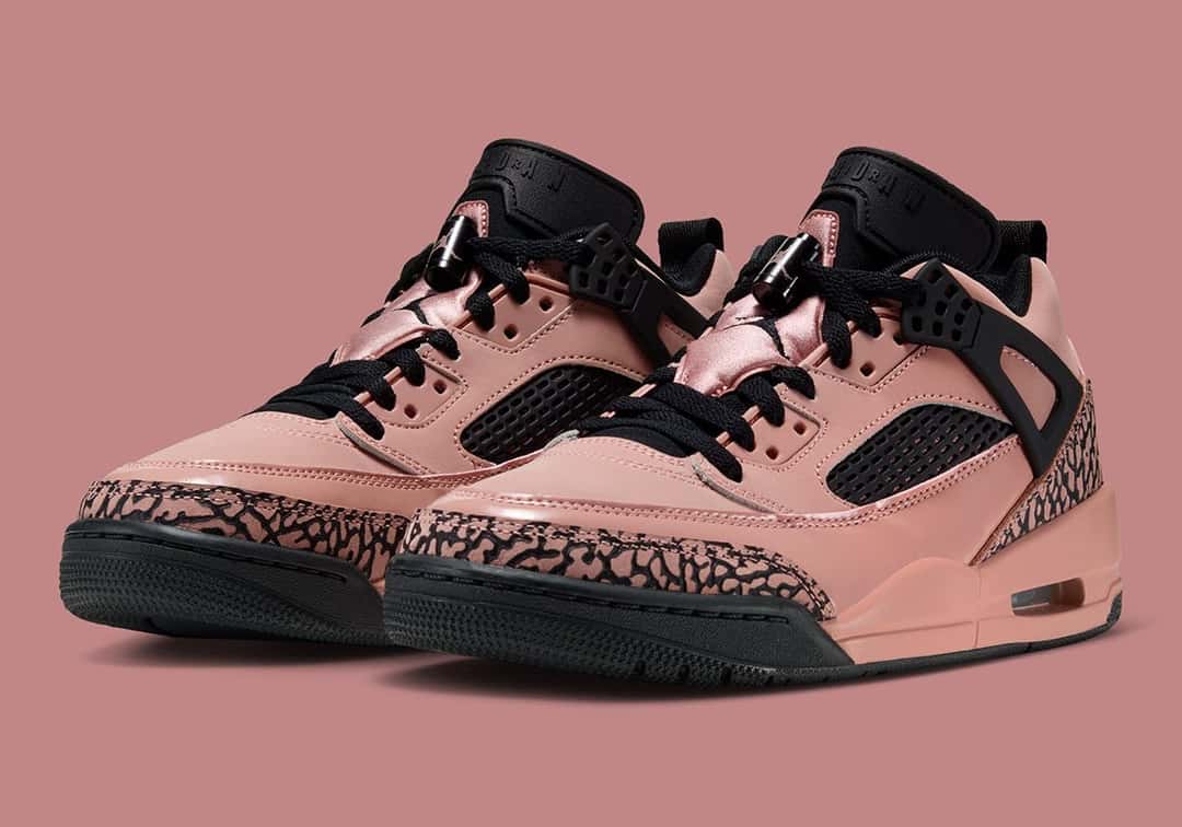 Par de la Jordan Spizike Low Rust Pink en vista de tres cuartos, con el charol rosa óxido, el estampado cemento en la puntera y los cordones negros