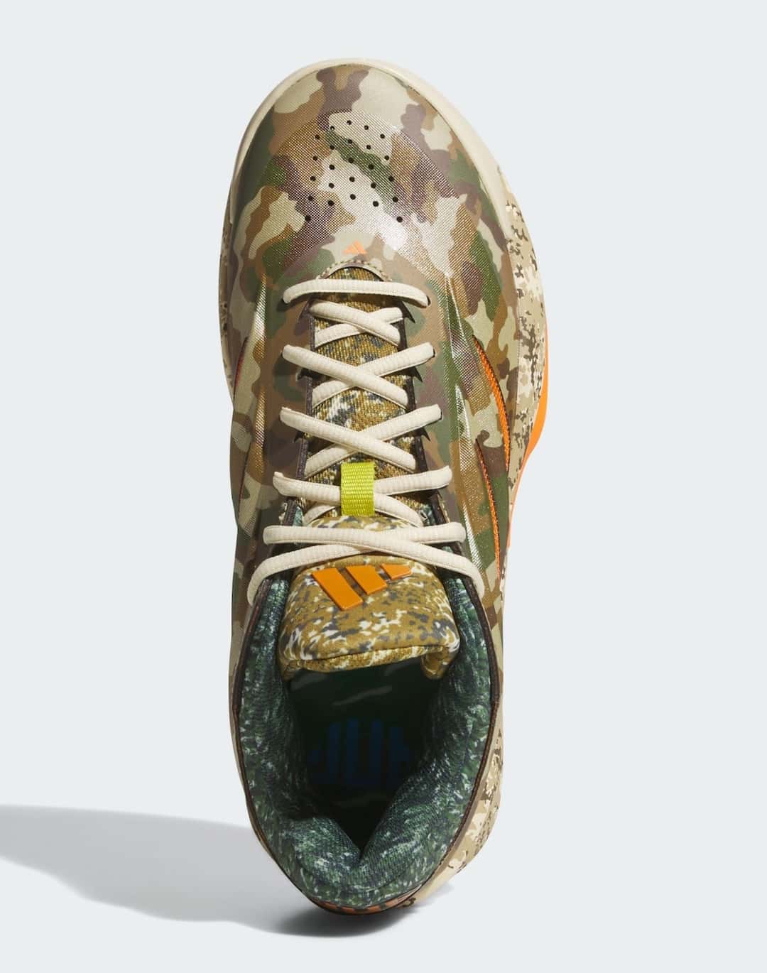 Vista desde arriba de la adidas Crazy Energy What The Camo, con los cordones beige, el camuflaje verde y marrón y el logo naranja en la lengüeta