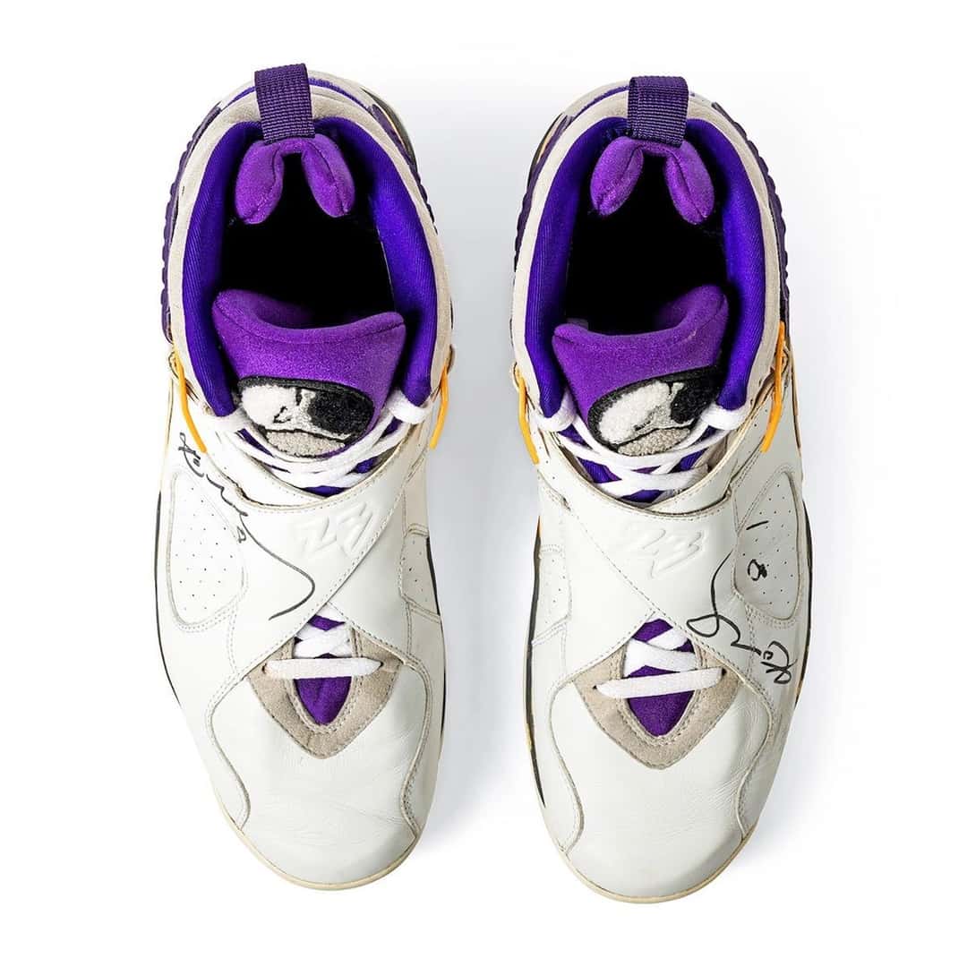 Vista desde arriba del par de Air Jordan 8 de Kobe Bryant, con las firmas en marcador negro sobre el cuero blanco y el forro violeta