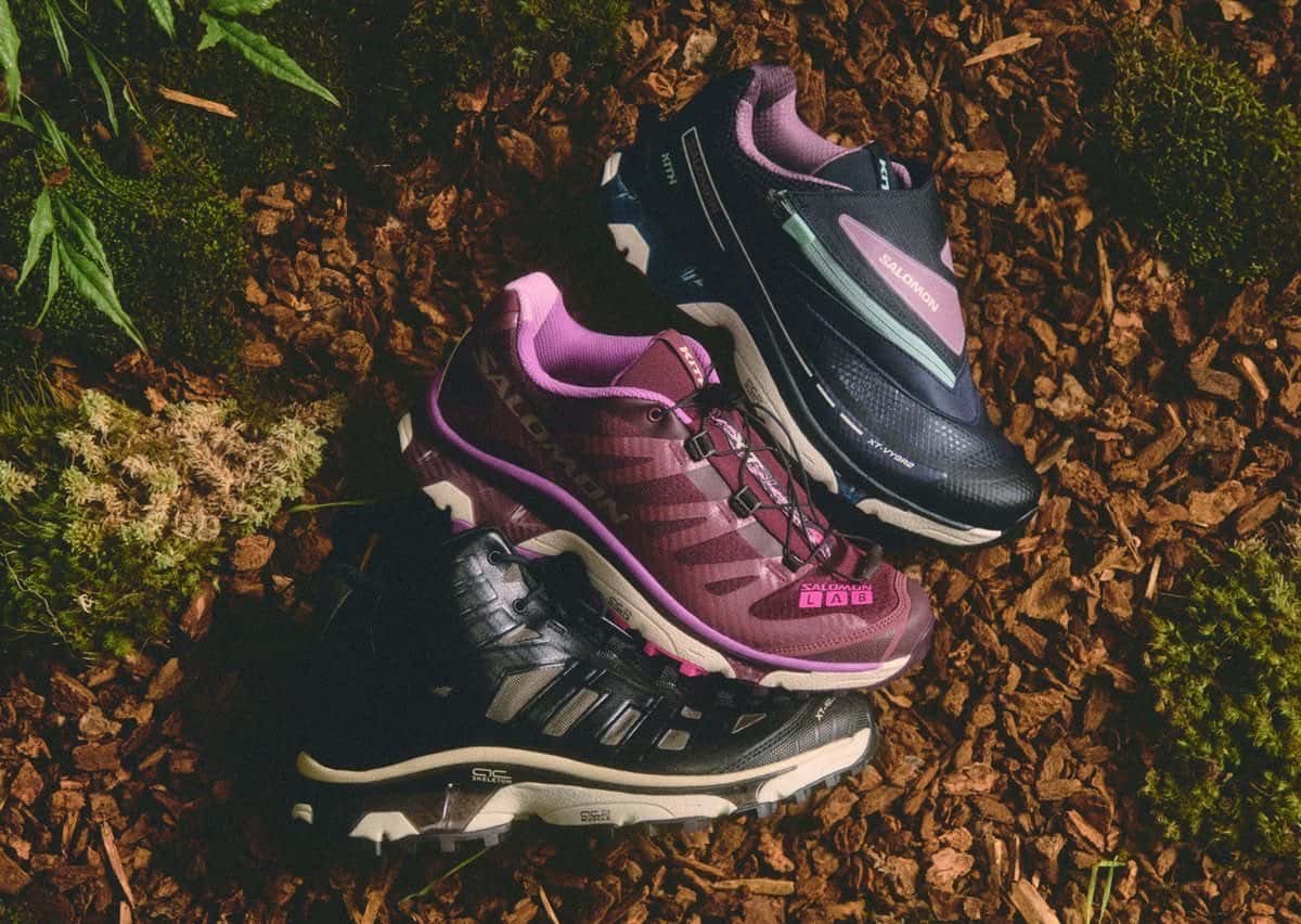Las tres zapatillas Kith x Salomon de invierno 2026, XT-4 OG bordó, XT-VYGR 2 azul marino y XT-4K Mid negra, apoyadas sobre corteza y hojas
