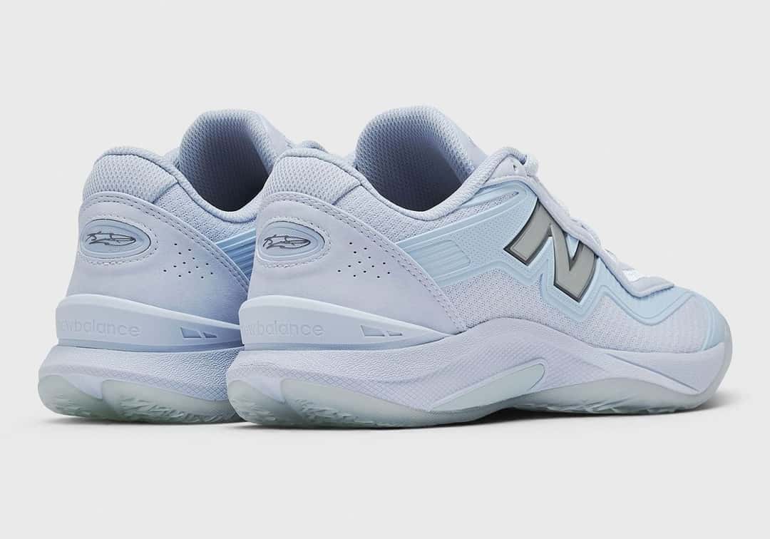 Par de New Balance Kawhi V Oxford Blue visto de atrás en diagonal, con la N plateada y el talón celeste