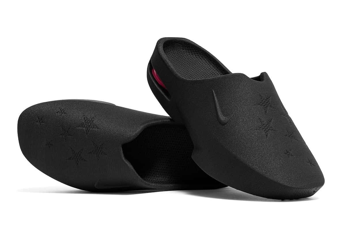Par de Nike Air Max Mule de Masyn en negro sobre fondo blanco, una apoyada y otra de costado, con estrellas en relieve en la suela y la capellada, el Swoosh en relieve y un detalle rosa en el talón