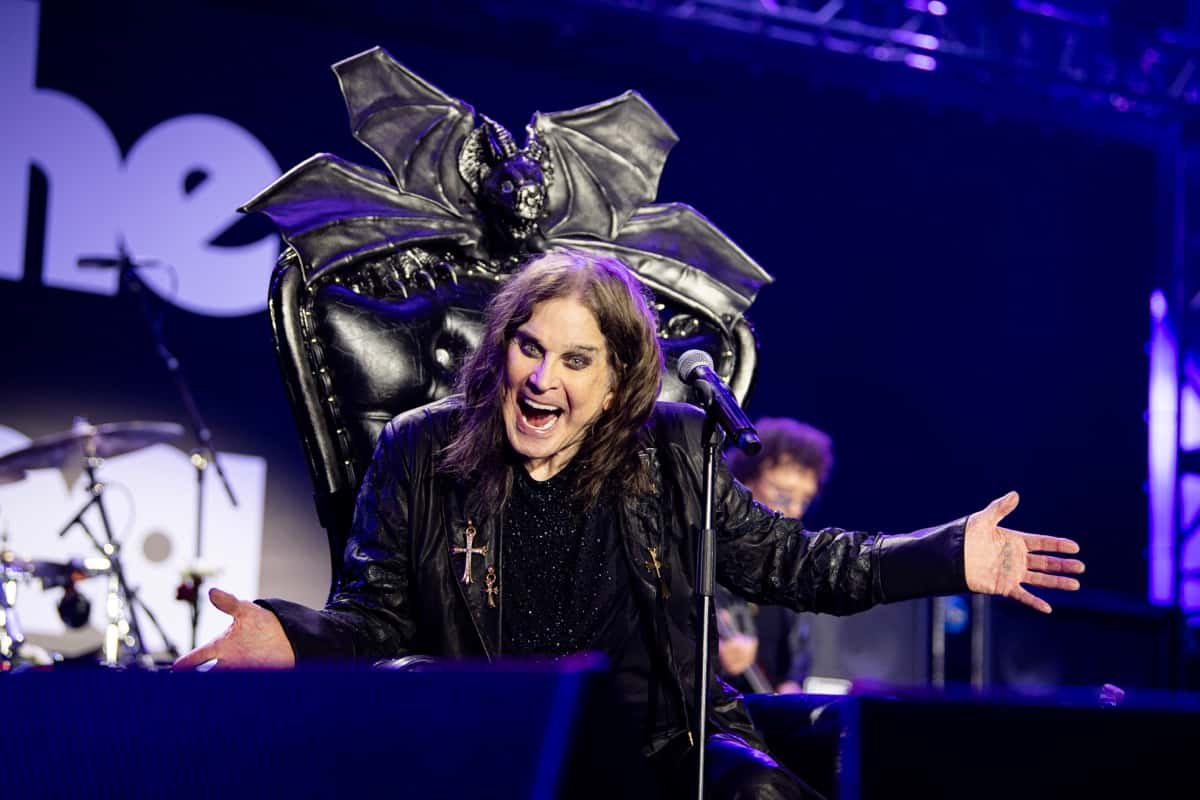 Ozzy Osbourne sonríe con los brazos abiertos sentado en un trono negro con alas de murciélago, frente al micrófono, en el show «Back to the Beginning» de Villa Park, Birmingham, el 5 de julio de 2025 (foto de archivo)