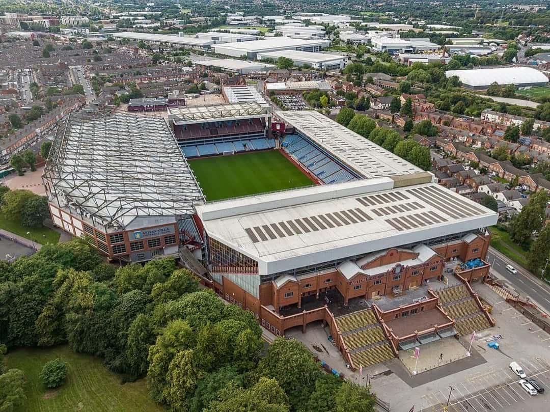 Vista aérea de Villa Park, el estadio del Aston Villa en Birmingham, con su techo plateado, las tribunas y el césped, rodeado de casas de ladrillo, en agosto de 2023 (imagen del lugar del show). Foto: Arne Müseler, CC BY-SA 3.0 DE, vía Wikimedia Commons