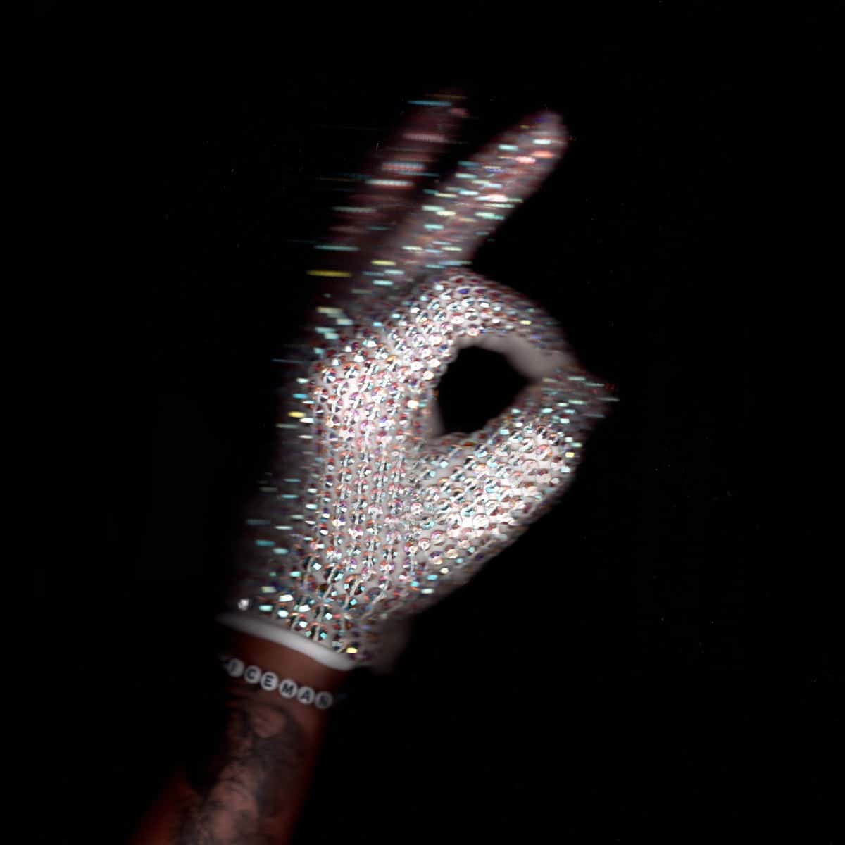 Portada oficial de "ICEMAN" de Drake: una mano con un guante cubierto de cristales brillantes hace el gesto de OK sobre un fondo negro, con una pulsera de cuentas que dice ICEMAN