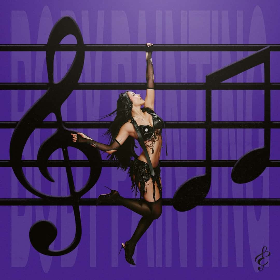 Portada de «Bodypainting», de Emilia: la cantante, con un body negro y medias de red, cuelga de un pentagrama gigante entre una clave de sol y notas musicales, sobre un fondo violeta