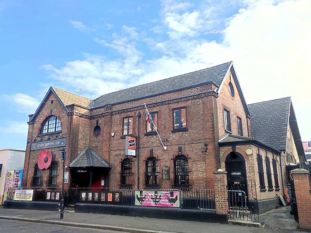 Fachada del General Browning Club, el edificio de ladrillo de Hackney, en Londres, donde funciona el MOTH Club, con su entrada y carteles en la reja, en septiembre de 2025 (imagen del lugar). Foto: Ewan-M, CC BY-SA 4.0, vía Wikimedia Commons