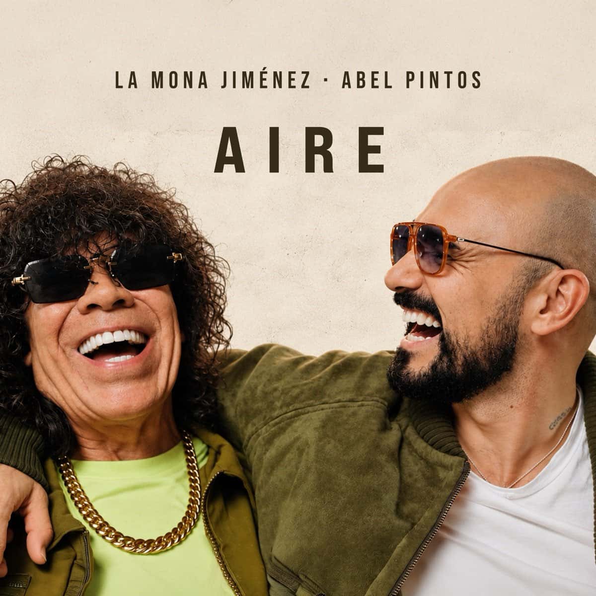 Portada de «Aire»: La Mona Jiménez, con anteojos negros y cadena dorada, y Abel Pintos, con anteojos de sol, se ríen abrazados sobre un fondo claro