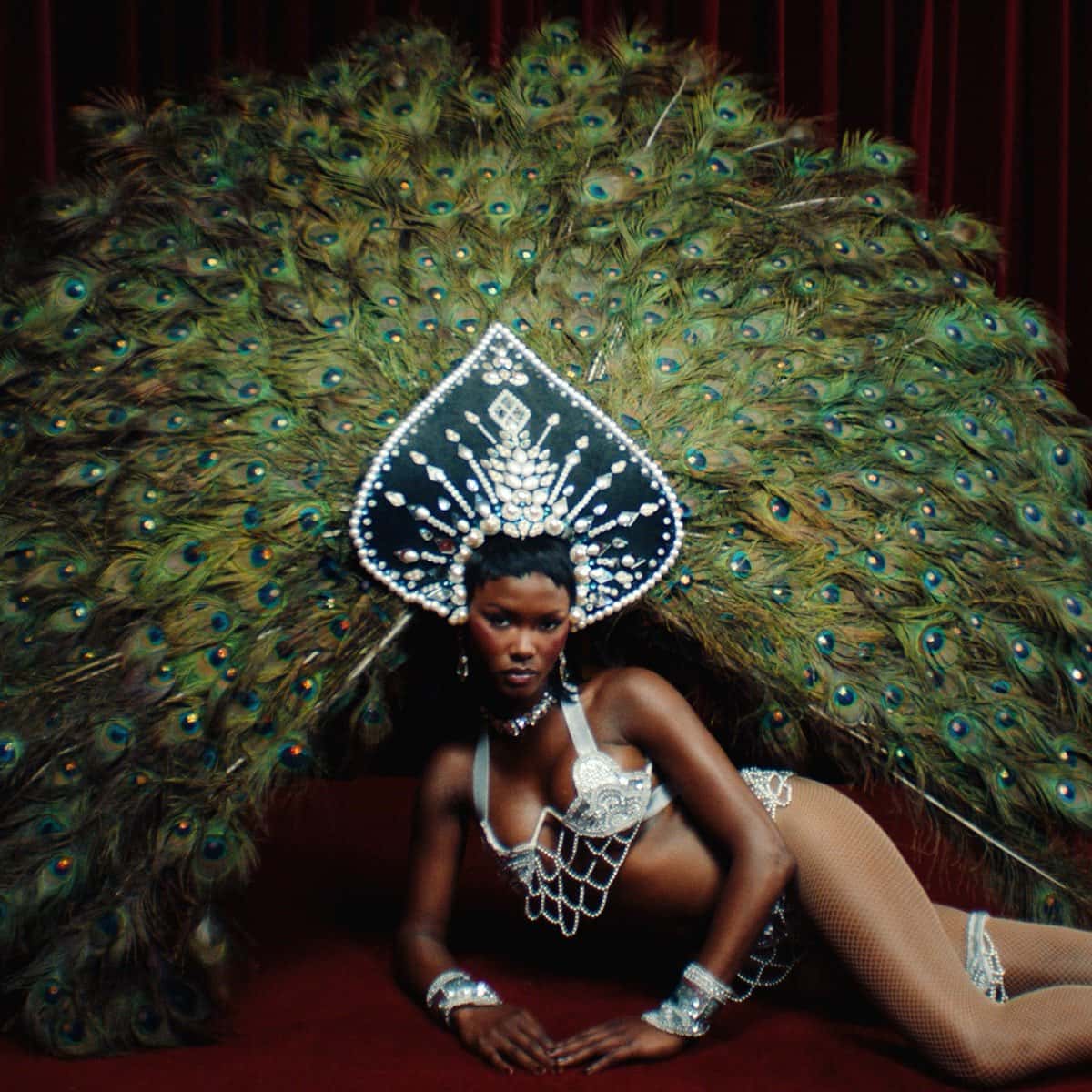 Portada de «Every Night», de Offset con Don Toliver: una mujer con un tocado de plumas de pavo real y joyas plateadas, recostada sobre un fondo rojo