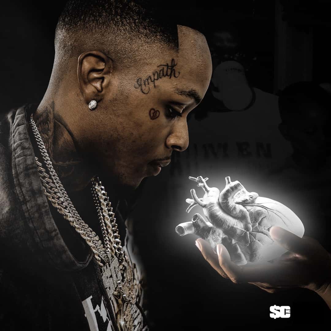 Portada de «Platinum Heart», el disco de 2020 de Toosii: el cantante de perfil, con cadenas y un tatuaje en la cara, sostiene un corazón blanco brillante sobre un fondo oscuro