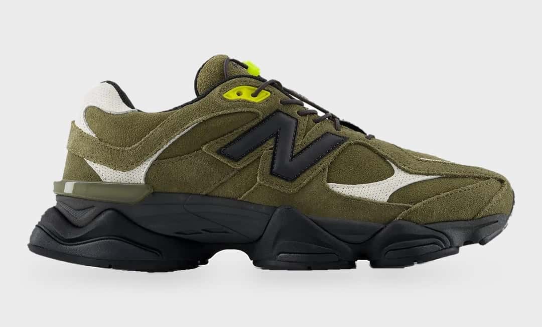 New Balance 9060 Trail verde oliva de perfil sobre fondo gris claro, con upper de gamuza verde, N negra grande, paneles blancos en la puntera y el talón, traba de cordones verde flúor y suela negra gruesa y ondulada