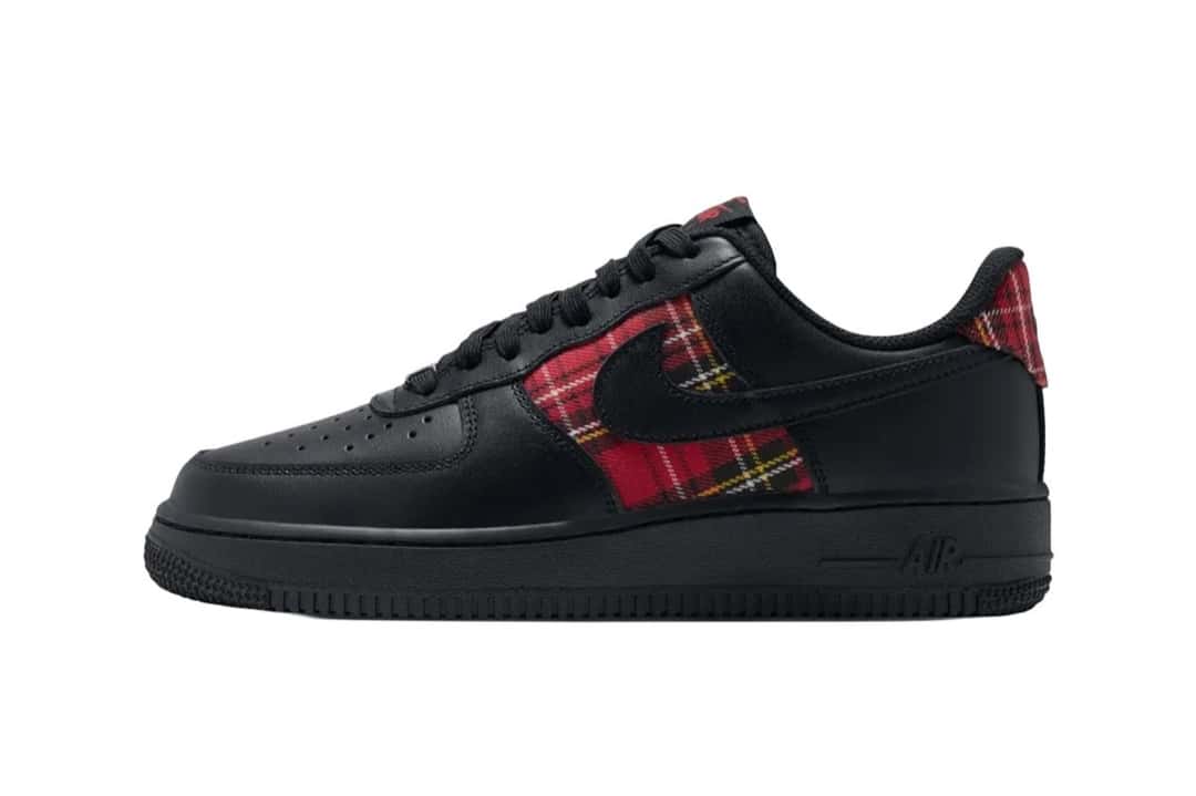 Nike Air Force 1 Low del Plaid Pack de perfil sobre fondo blanco, con cuero negro en casi todo el upper y tela escocesa roja en los laterales y el talón