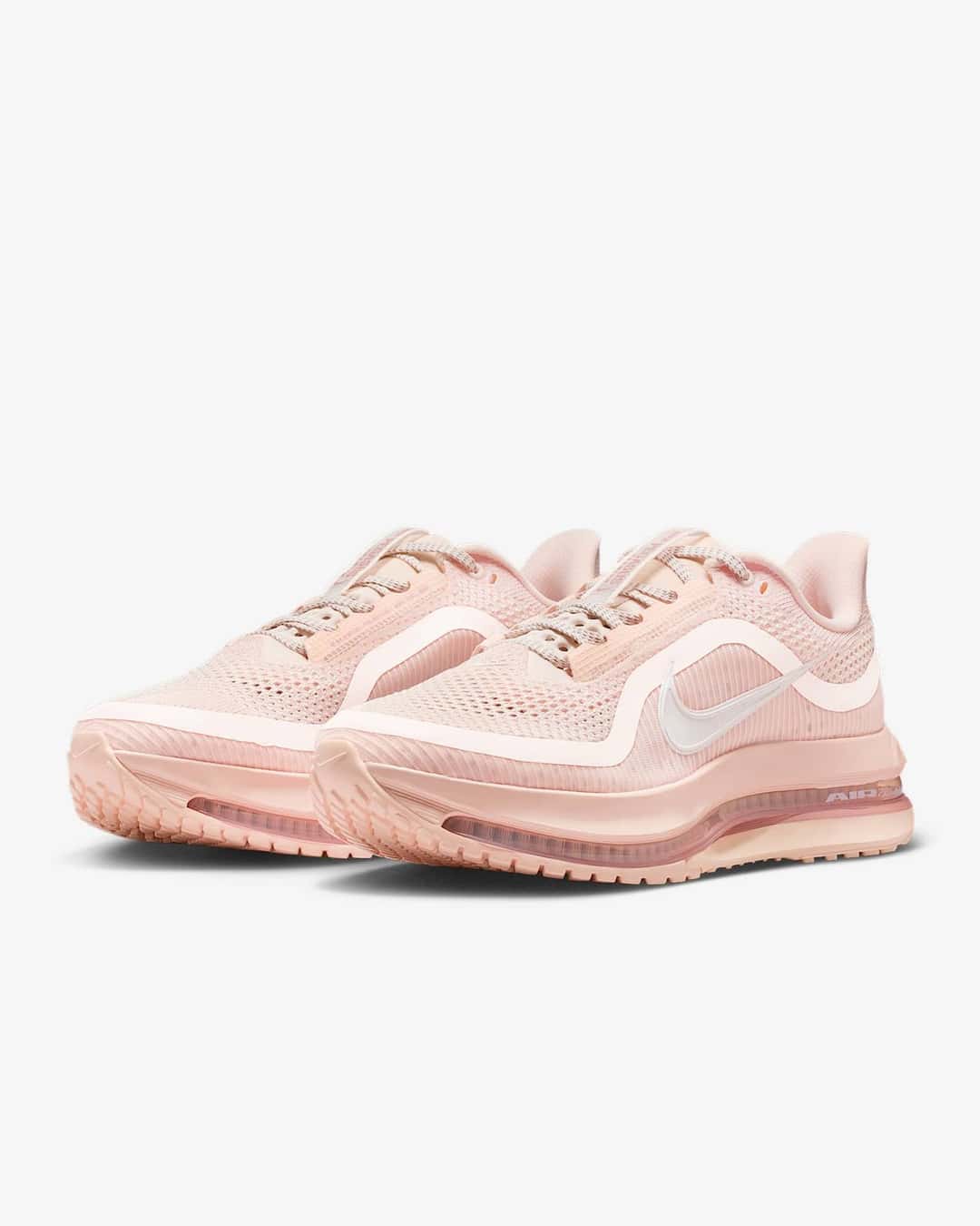 Par de Nike Pegasus Premium Guava Ice en vista diagonal, con malla durazno, Swoosh blanco y entresuela rosada