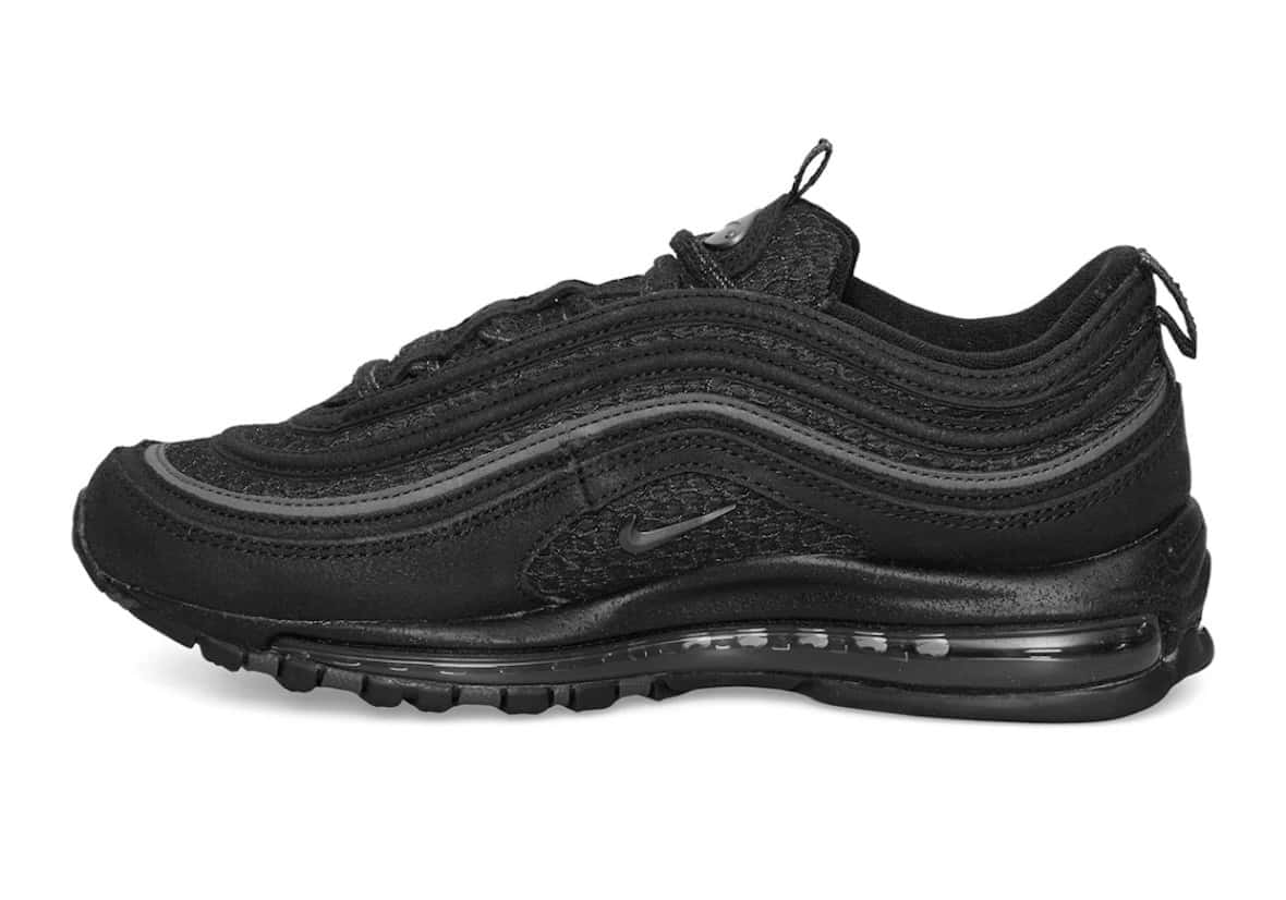 Slam Jam x Nike Air Max 97 de perfil, toda negra, con las líneas onduladas en gris oscuro y la cámara de aire visible en la suela