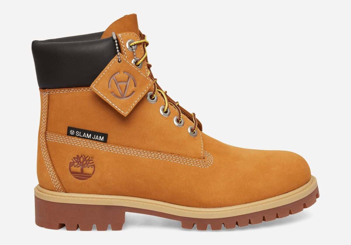 Bota Timberland 6-Inch de Slam Jam en nobuk color trigo, con etiqueta Slam Jam en el lateral y colgante de cuero con cadena plateada