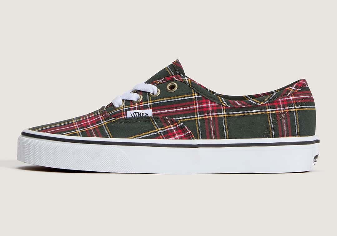 Vans Authentic Tartan Oil Green de perfil sobre fondo crema, con upper de lona en tartán verde oscuro cruzado por líneas rojas, amarillas y blancas, ojalillos dorados, cordones blancos, etiqueta Vans en el costado y suela blanca con línea negra